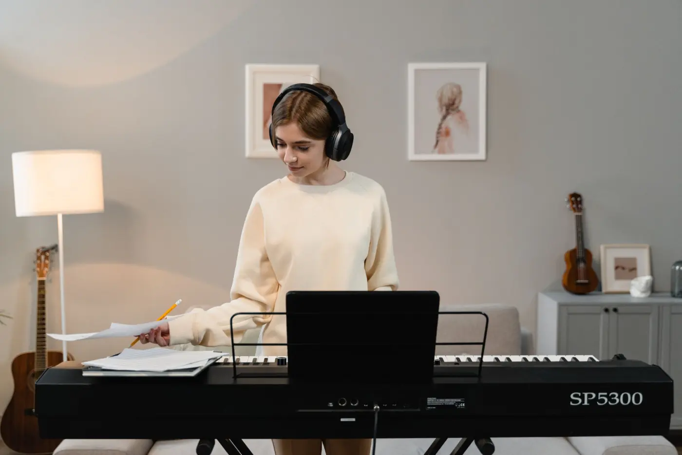 A woman wearing headphones and playing an electronic keyboard
